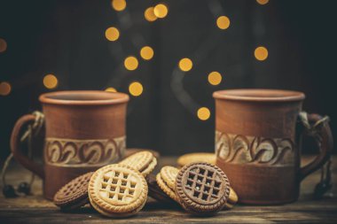 Yuvarlak tatlı kurabiyeler ve bir fincan çay eski usul ahşap bir masada.