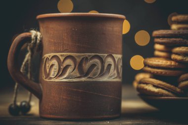 Yuvarlak tatlı kurabiyeler ve bir fincan çay eski usul ahşap bir masada.