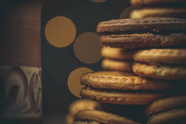 Yuvarlak tatlı kurabiyeler ve bir fincan çay eski usul ahşap bir masada.