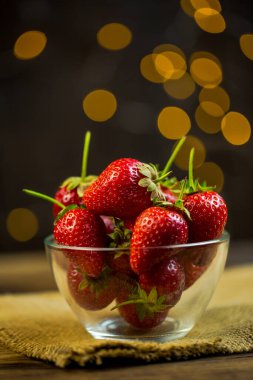 Olgun kırmızı çilekler, arka planda bulanık romantik renkler..