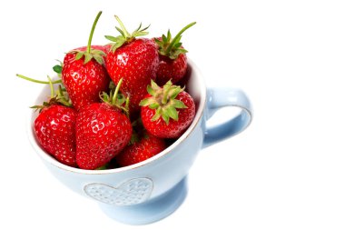 Beyaz arka planda mavi bardakta çilekler