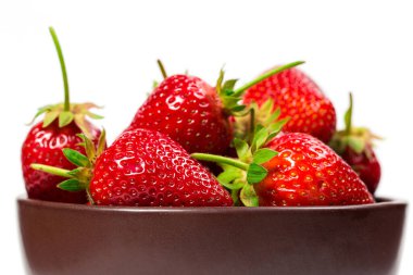 Kahverengi tabakta beyaz arka planda çilekler