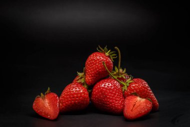 Siyah arka planda olgun kırmızı çilekler.