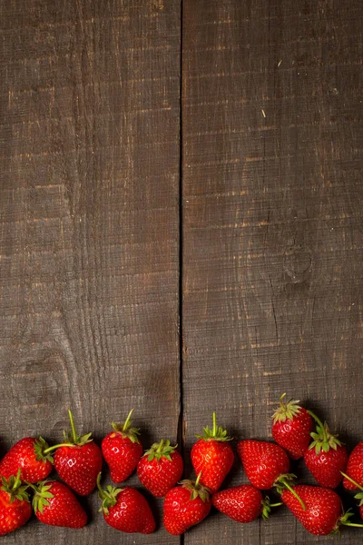 褐色木制底座上成熟的红草莓 — 图库照片