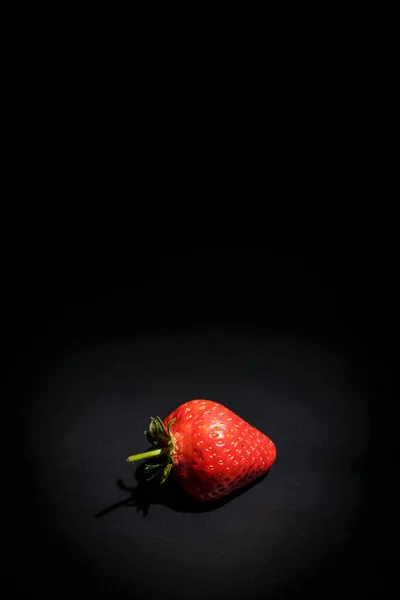 Ripe red strawberries on a black background