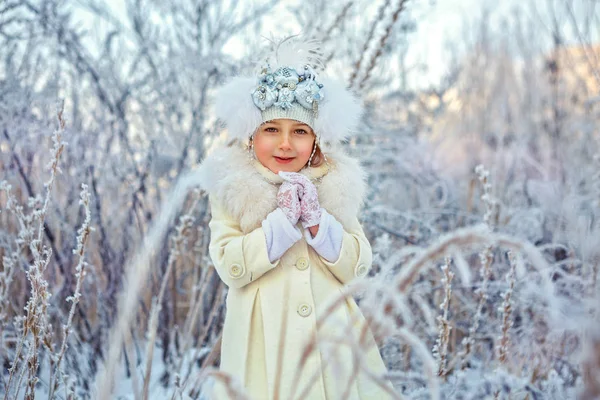 Menina criança adorável feliz em chapéu de pele e casaco na floresta de inverno — Fotografia de Stock