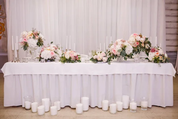 Décor de table avec des fleurs blanches et des bougies pour une fête de mariage — Photo