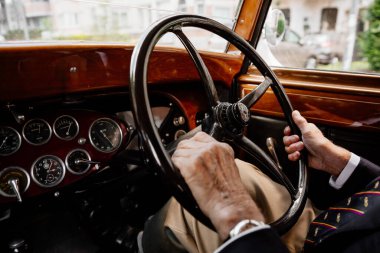 Sürücü elleri Retro arabanın direksiyonunda.