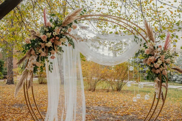 Kristal damlalardan yapılmış bir düğün kemerinde çiçek bileşimi. Düğün töreni için modern bir ortam..