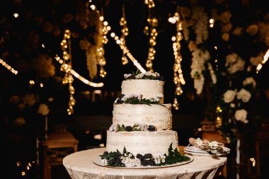 Düğün pastası. Arka planda kemer ve gece ışıkları var.