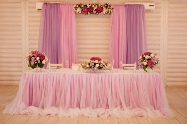 Bir restoranda düğün dekorasyonu. Çiçek kompozisyonu ile servis edilen bir masa.