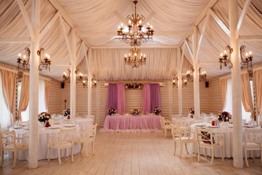 Bir restoranda düğün dekorasyonu. Çiçek kompozisyonu ile servis edilen bir masa.