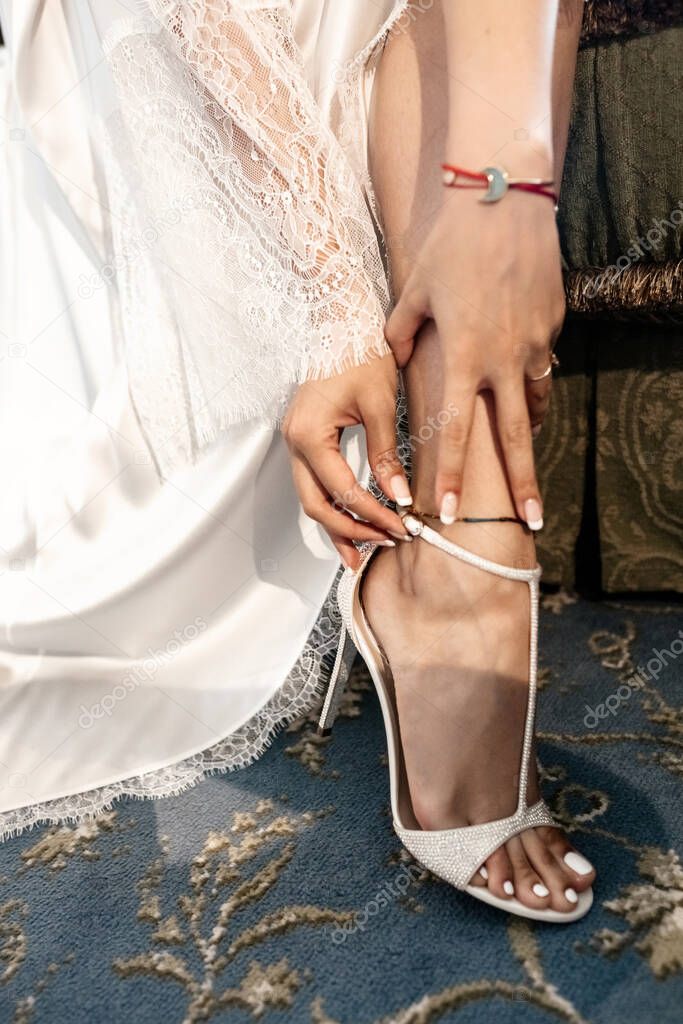 Bride fixing her shoes in the morning