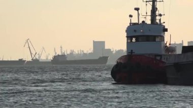 Tekne rıhtımda tug. Yollar yük gemisi aşırı.