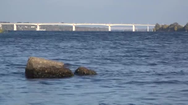 橋の近くのドニエプル川沿いを歩きます。地平線上の橋. — ストック動画
