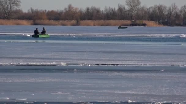 Transport för rörelse på isen. Vintern, två män i en båt. Korsningen på vintern på floden. — Stockvideo