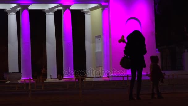 Una niña con un niño esperando el tráfico a lo largo de la carretera . — Vídeos de Stock