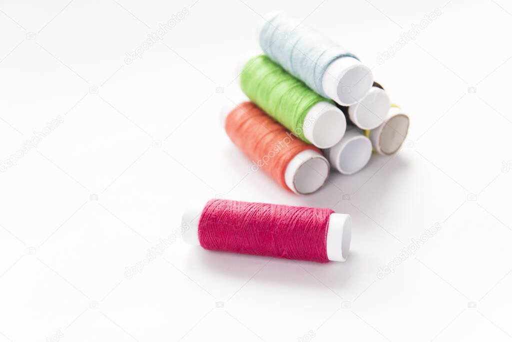 colorful spools of thread close-up on a white background