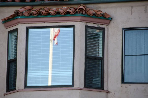 Bandeira americana refletindo na janela de um resort no sul do Califa — Fotografia de Stock