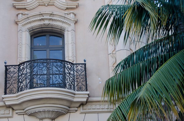 Details of a balcony next to a palm tree on El Prado in Balboa park, San Diego