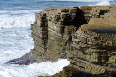 Loma Point Tidepool Parkı 'ndaki kayalıkların yakınında güçlü bir sörf.