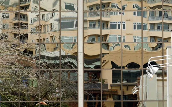 Οπτικές ψευδαισθήσεις και αντανακλάσεις της πόλης σε γυάλινο τοίχο του διαμερίσματος — Φωτογραφία Αρχείου