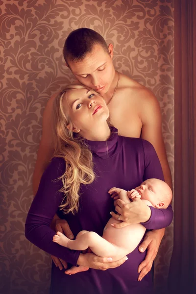 Familia feliz marido, esposa y bebé recién nacido posando en casa por —  Fotos de Stock