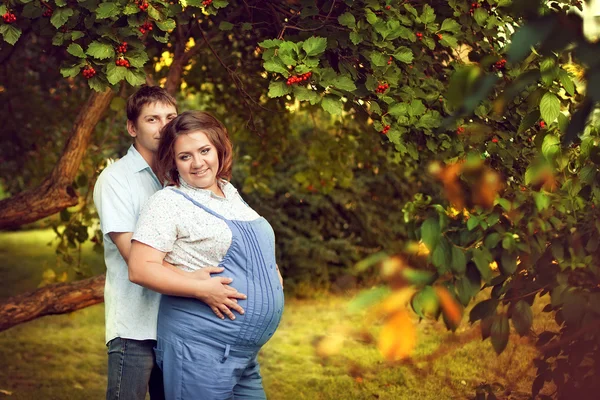 Pareja feliz esperando un bebé camina en verano en un hermoso par —  Fotos de Stock