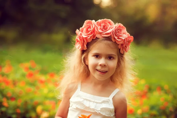 Szczęśliwe dziecko w Wieniec kwiatów na zewnątrz w lecie park — Zdjęcie stockowe