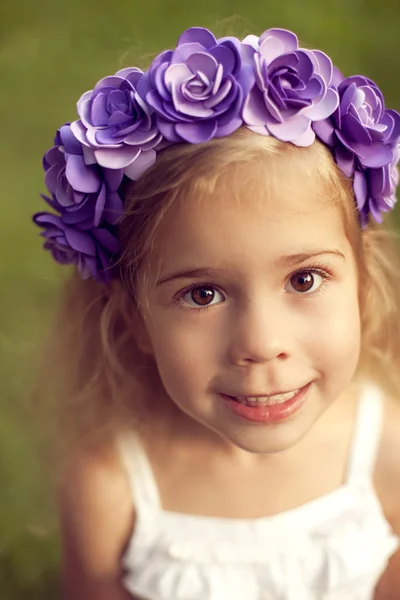 Счастливый ребенок в венке из цветов под открытым небом в летнем парке — стоковое фото