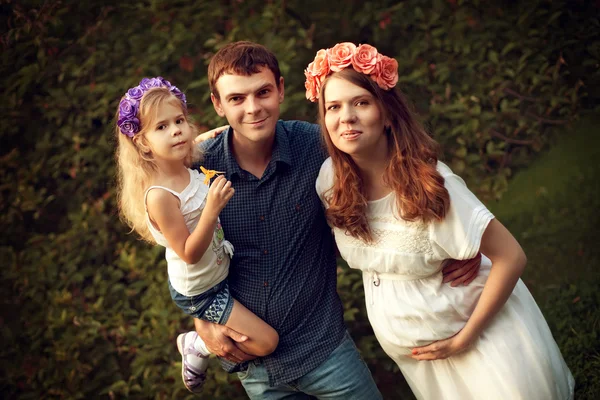 Familia feliz de tres personas - una madre embarazada, padre y dau —  Fotos de Stock