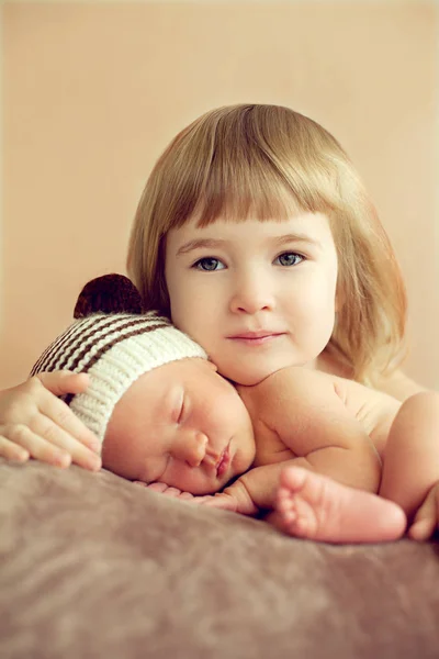 Mała dziewczynka przytulanie brata snu noworodka. O miłości Zdjęcie Stockowe