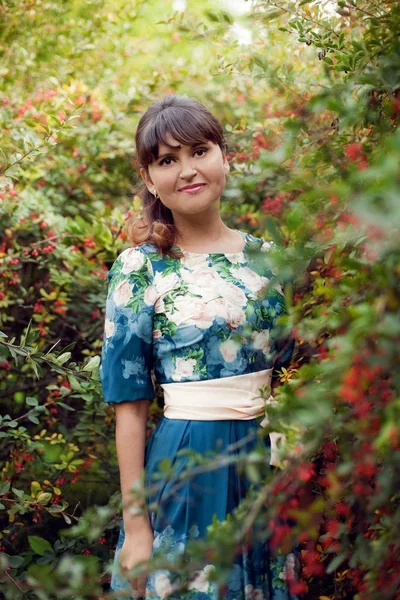 Beautiful happy brunette woman in the park on a warm summer day — Stock Photo, Image