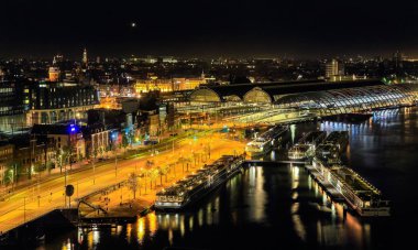 Amsterdam, Hollanda - 10 Mayıs 2016: River cruise terminal ile gemi ve Amsterdam Centraal tren istasyonunda gece