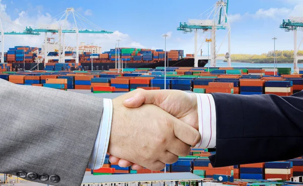 Closeup of business people handshake on container terminal with cranes background