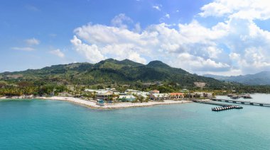 Güneşli bir günde turist gemileri ve tatil köyleri için rıhtımı olan tropikal tatil beldesi Amber Körfezi manzarası.