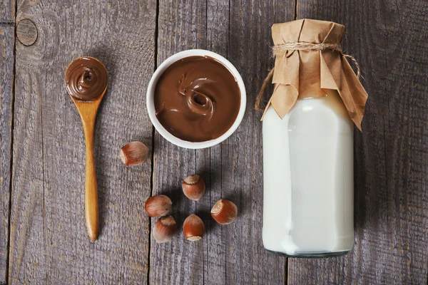 Chocolade hazelnootpasta en fles melk — Stockfoto