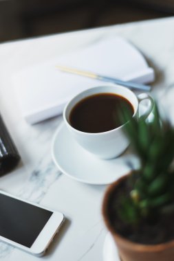 kahve, telefon ve boş not defteri 