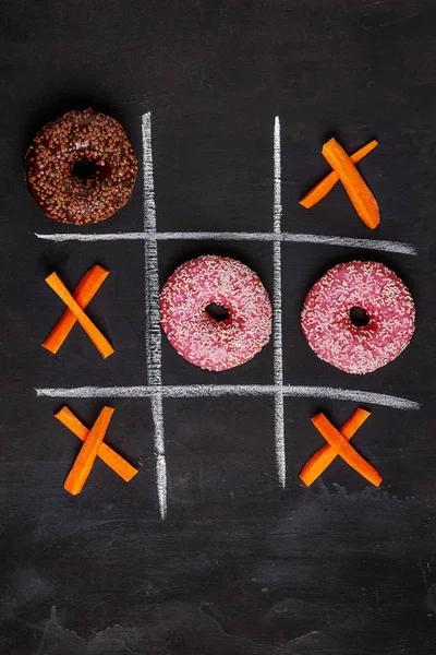 Donas tic-tac-toe vs zanahorias —  Fotos de Stock