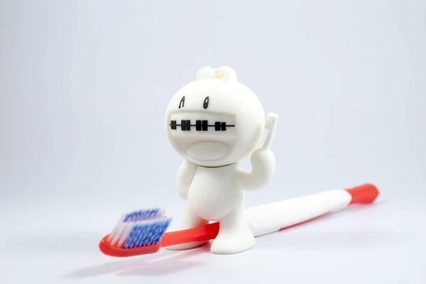 A braces doll and a toothbrush. — Stock Photo, Image