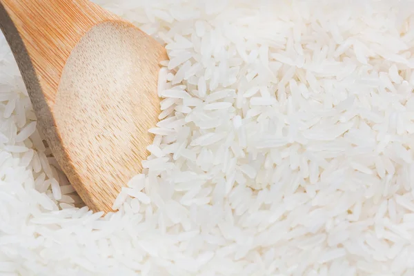 Сырой рис с деревянной ложкой вблизи — стоковое фото