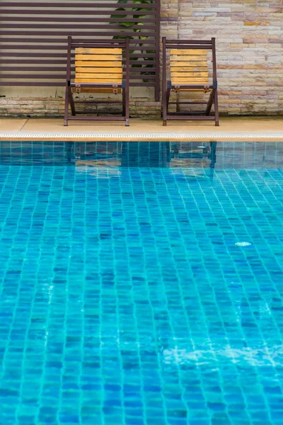 Chair on ground beside swimming pool