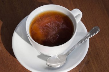 Bir fincan sade kahve ve süt ahşap tablo.