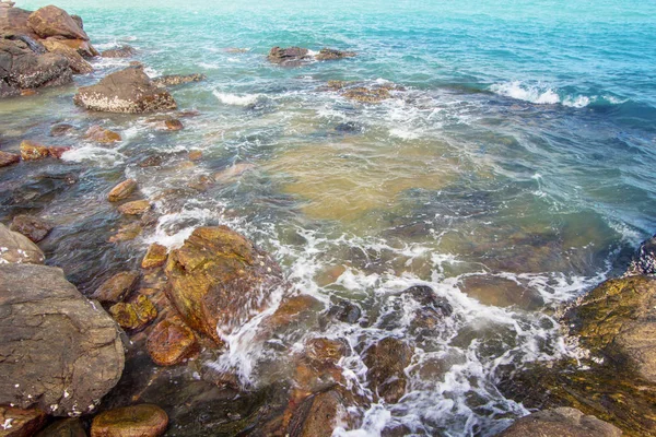 Dalgalar bir kayalık plaj