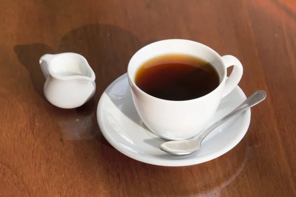 Una taza de café negro y leche en la mesa de madera . — Foto de Stock