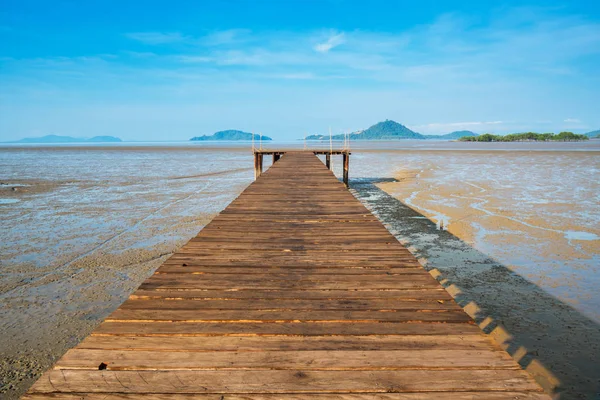 Trä bro över mark sträcker sig in i havet under ebb tide tid — Stockfoto
