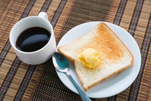 Mesa servida para café da manhã com torrada, café e manteiga na mesa — Fotografia de Stock