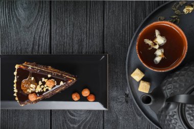 Siyah çaydanlık ve yeşil çay, kilden bir fincanda yasemin.