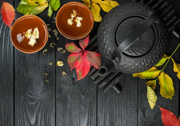 Tetera negra y té verde con jazmín en una taza de barro — Foto de Stock