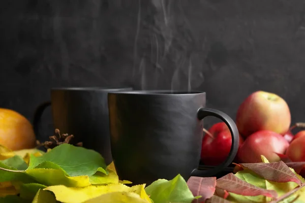 Herfst stilleven. Twee zwarte mokken met warme thee in herfstgeel — Stockfoto